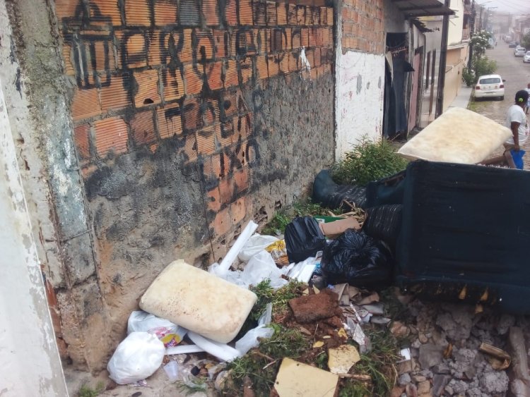 São Sebastião do Passé- Esquina que tem o aviso de  "Proibido Jogar lixo" , acumula lixo e sofá.